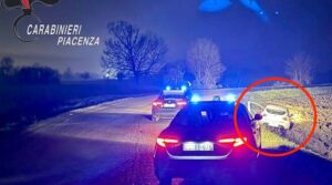 Auto incidentata sulla strada al buio, coinvolte due veicoli, emergenza con polizia e servizi di soccorso, scena di un incidente stradale notturno in Emilia Romagna.