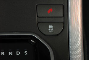 Illustrazione di pulsante di sicurezza in auto con funzione di controllo della stabilità e sistemi di sicurezza attivi.