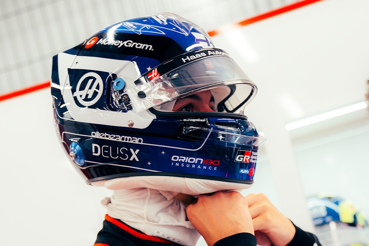 Casco da gara Formula 1 con visiera protettiva, sponsorizzazioni e dettagli tecnici, utilizzato da un pilota professionista durante le sessioni di gara.